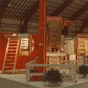 Foto dello stand espositivo Dolle nel 1984, con scale rosse e una vetrina di prodotti in un contesto fieristico.