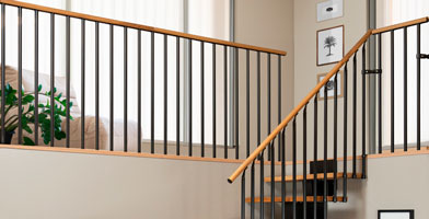 Un pianerottolo con parapetti robusti ed eleganti, che uniscono corrimano in legno e balaustre in metallo per un tocco moderno.