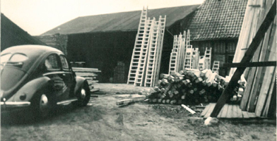 Foto storica del gruppo DOLLE, con veicoli d'epoca e strutture industriali.