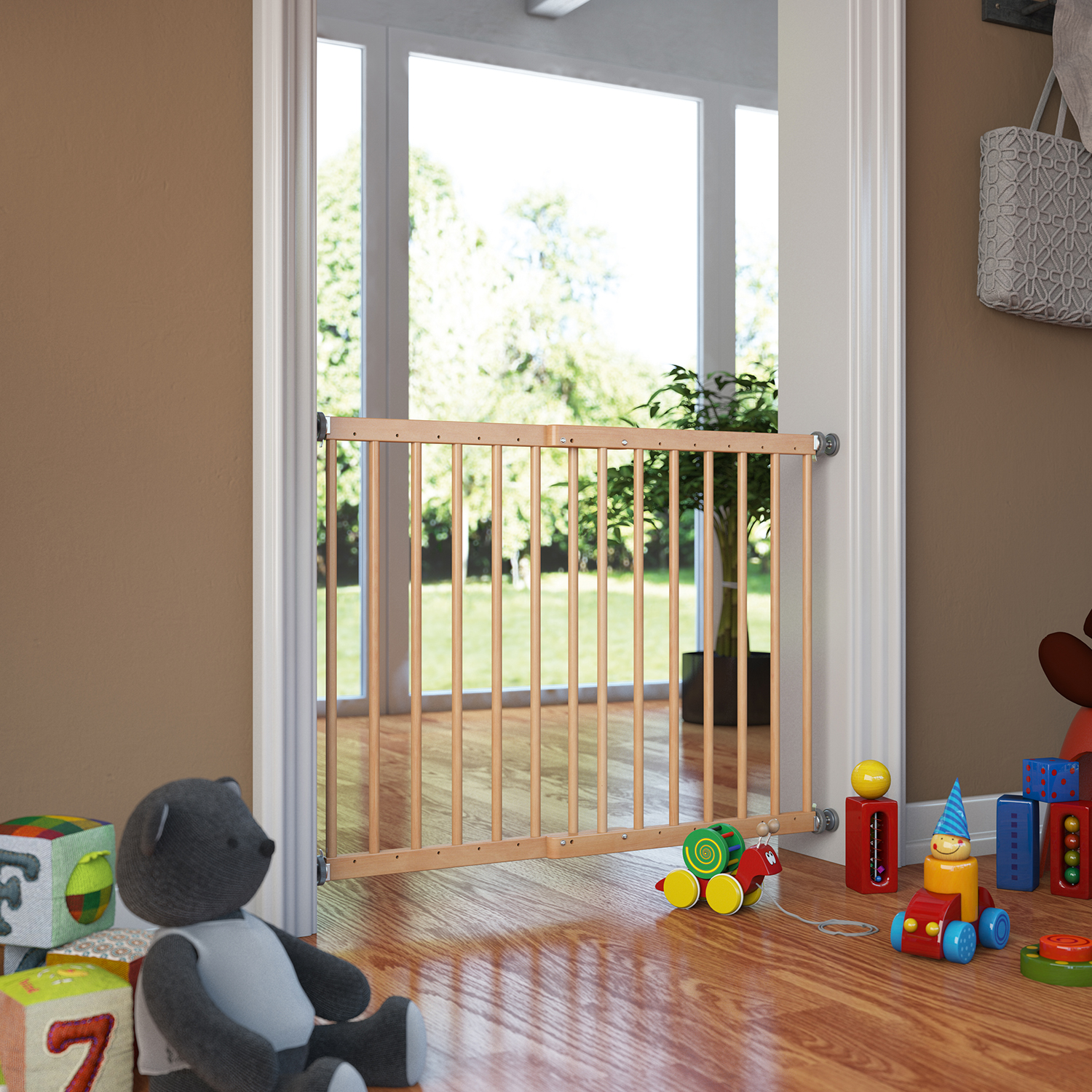 Cancelletto di sicurezza in legno installato in una porta, in una stanza con giocattoli per bambini sul pavimento e vista su un giardino sullo sfondo.