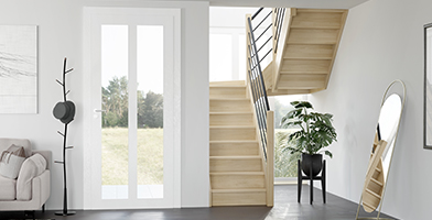  Immagine di un interno moderno e luminoso con una scala in legno su misura che conduce al piano superiore.