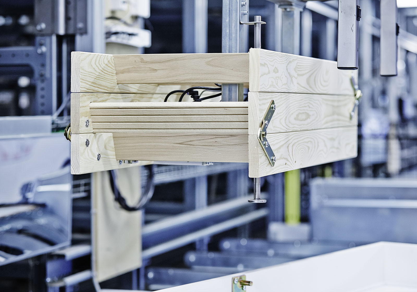 Telaio in legno per scala retrattile con cerniere e supporti metallici, mostrato durante l’assemblaggio in uno stabilimento di produzione.
